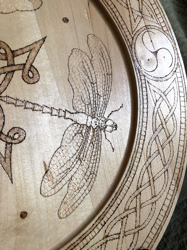 Closeup of hand drawn wood burned dragonfly artwork by Di's Studio Designs.
