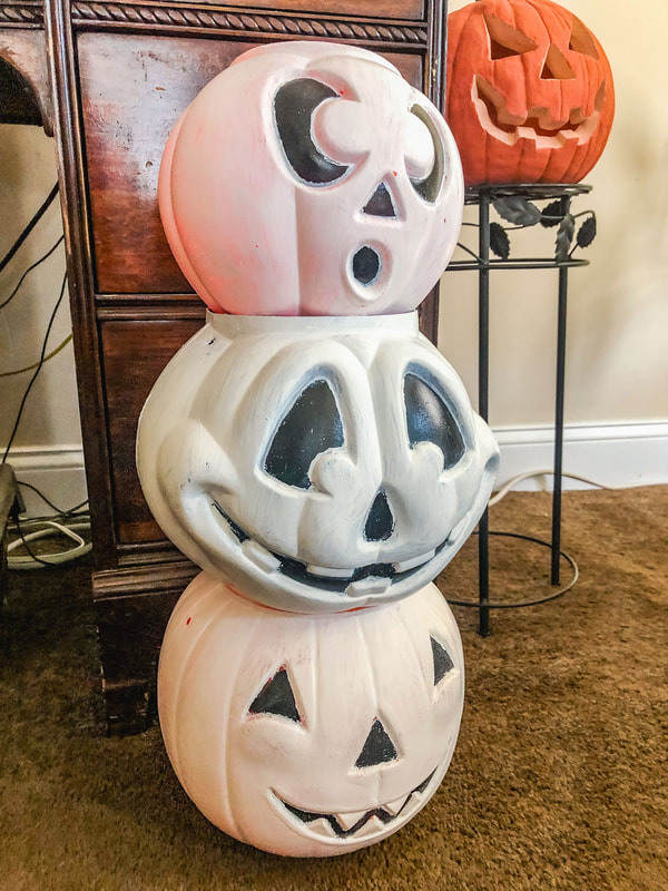 Plastic Halloween candy buckets painted white and stacked.