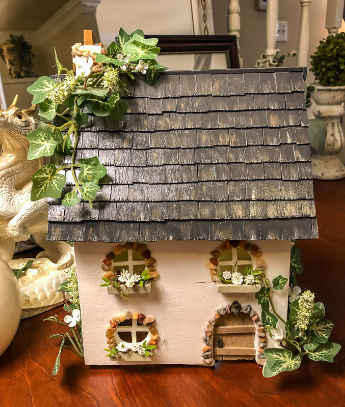 Handcrafted miniature English cottage with faux florals.