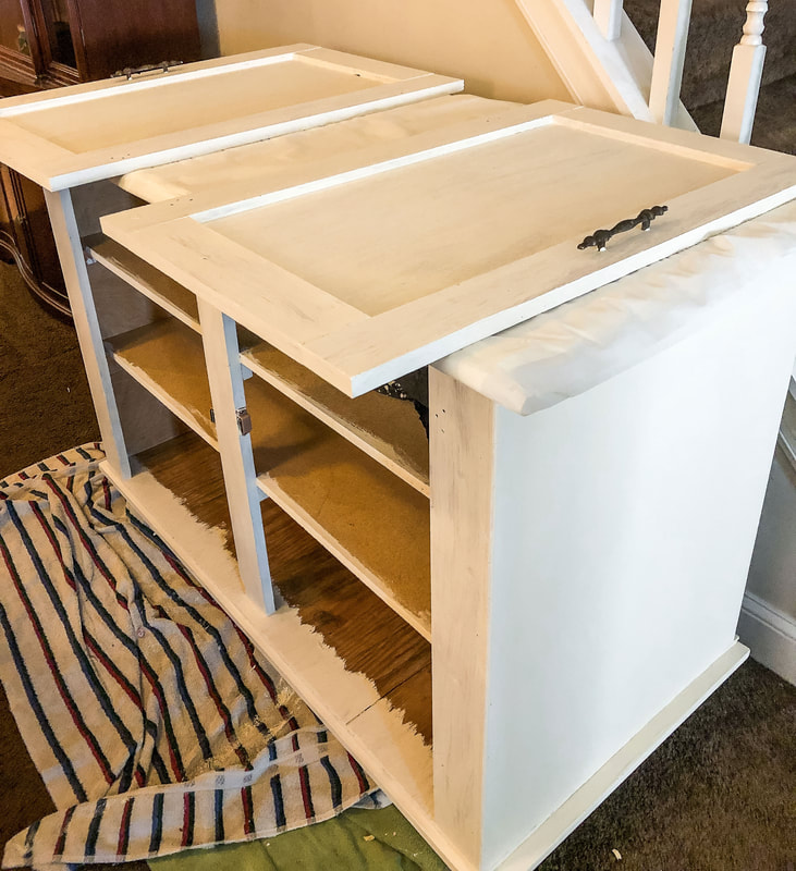 In progress shot of a DIY project chalk painting a freestanding wood cabinet.