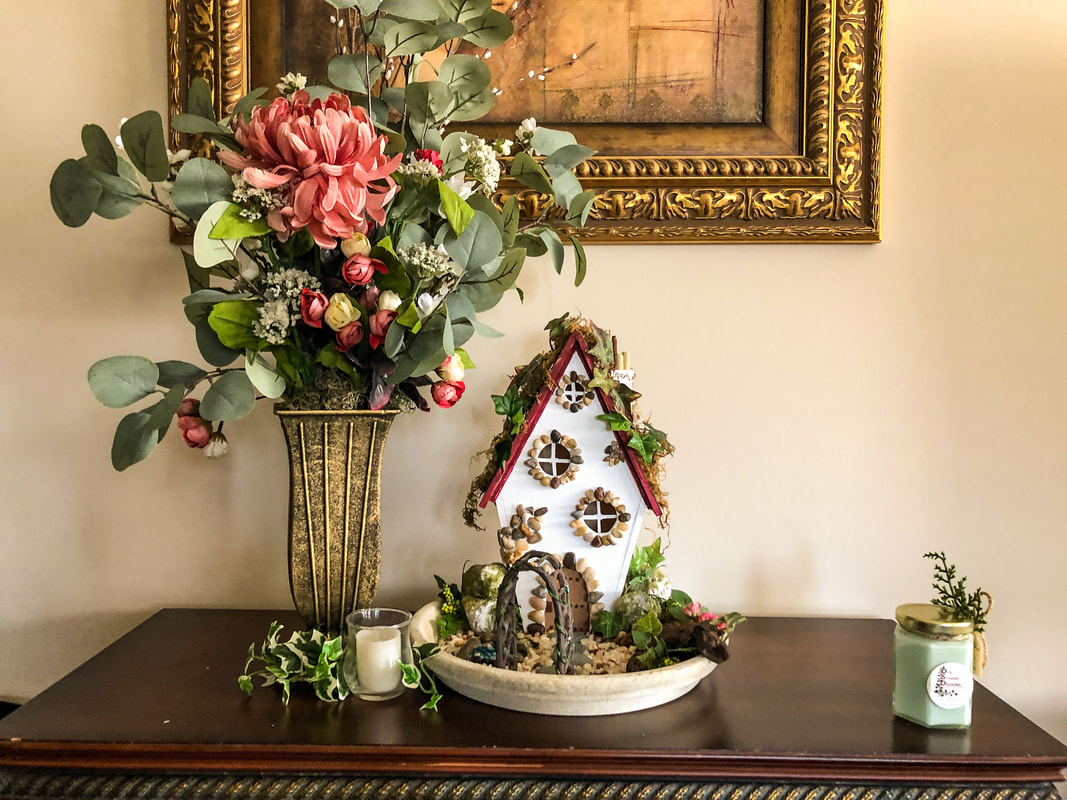 Handcrafted fairy cottage with an indoor fairy garden  with faux florals.