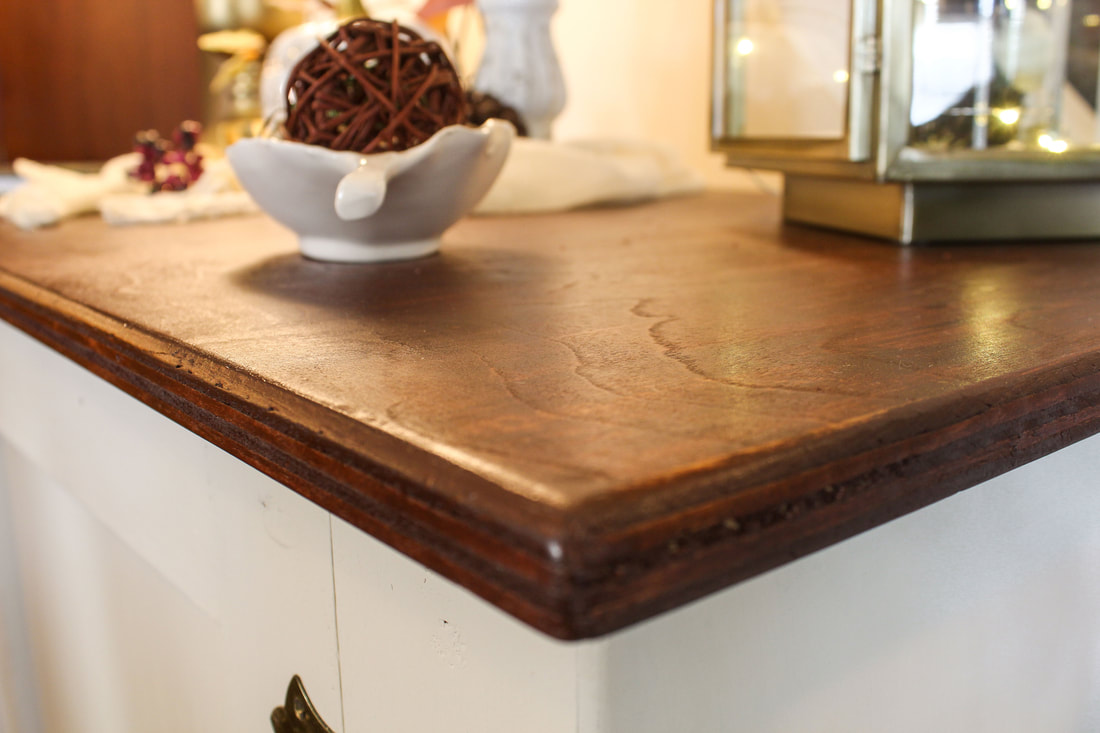 Closeup of the top of a recently stained wood cabinet.