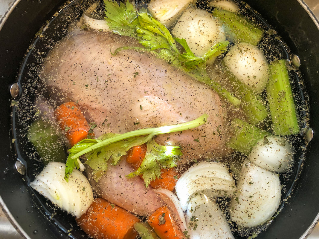 Pot with chicken and vegetables cooking for chicken soup.