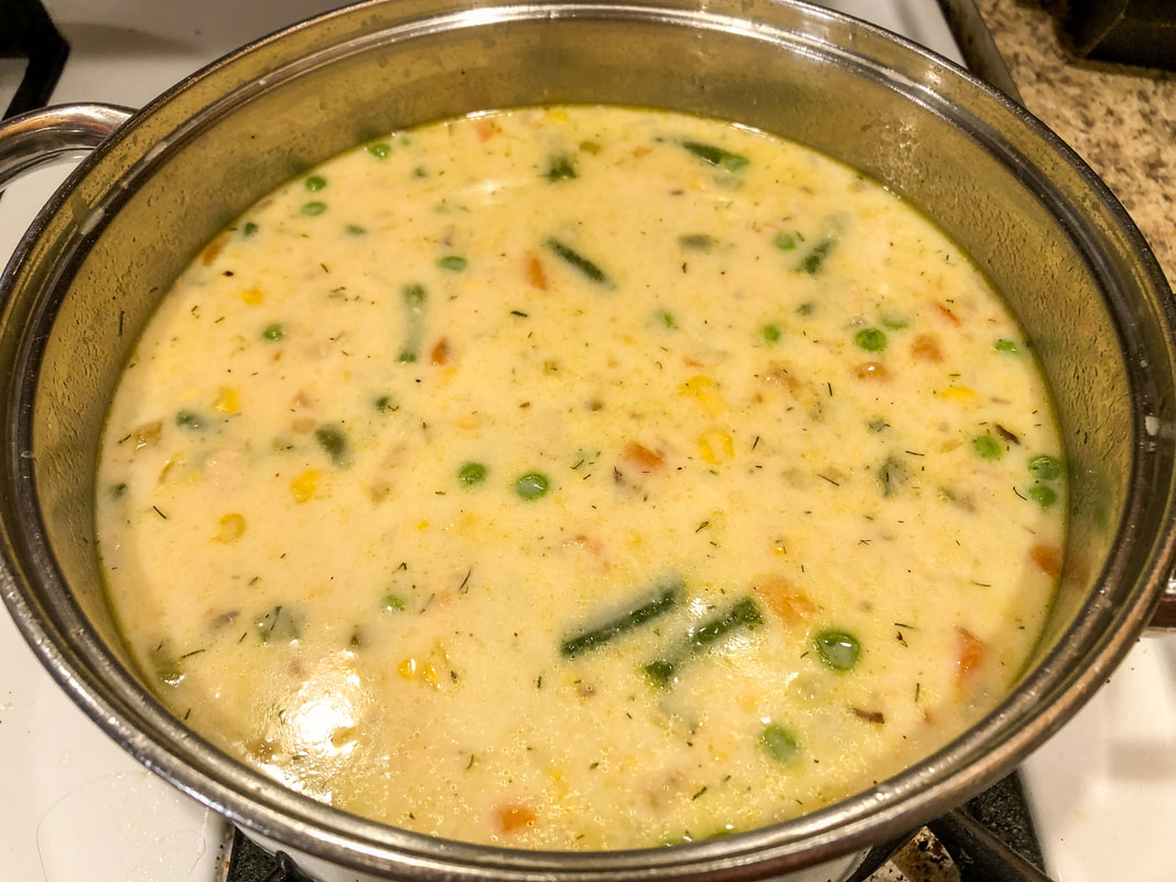 Salmon chowder cooking on a pot on the stove.