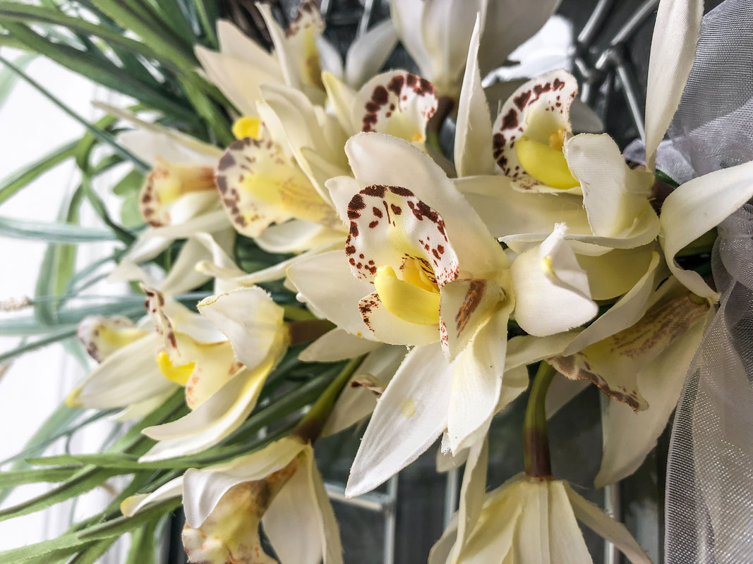 Faux orchids on a decorative spring wreath.