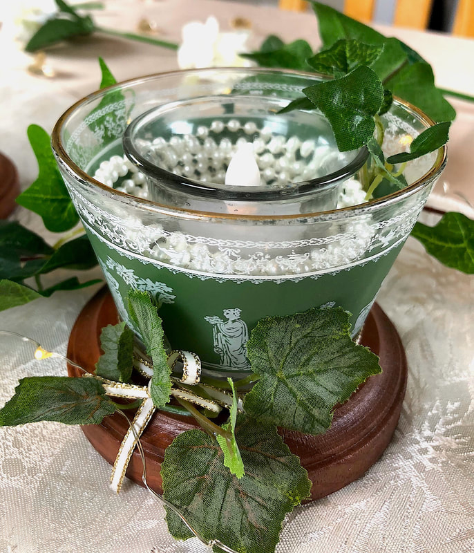 Repurposed green Greek themed cocktail glasses repurposed as a decorative candleholder