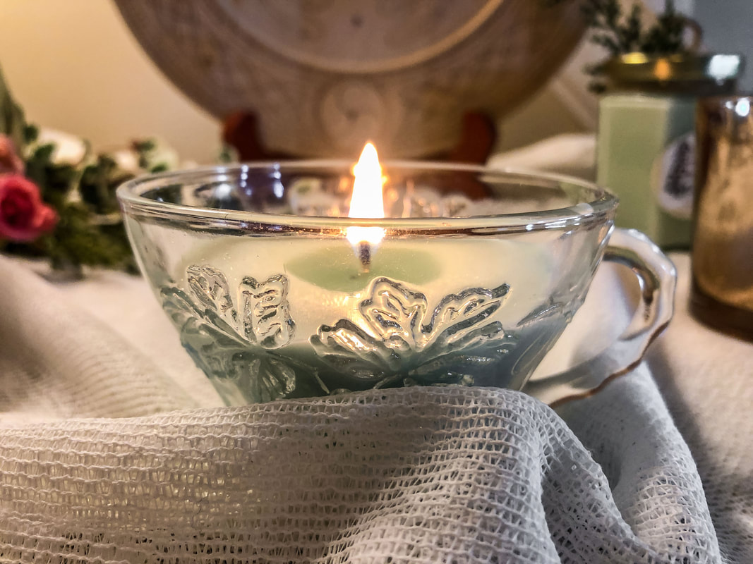 Homemade soy candle burning in a glass tea cup