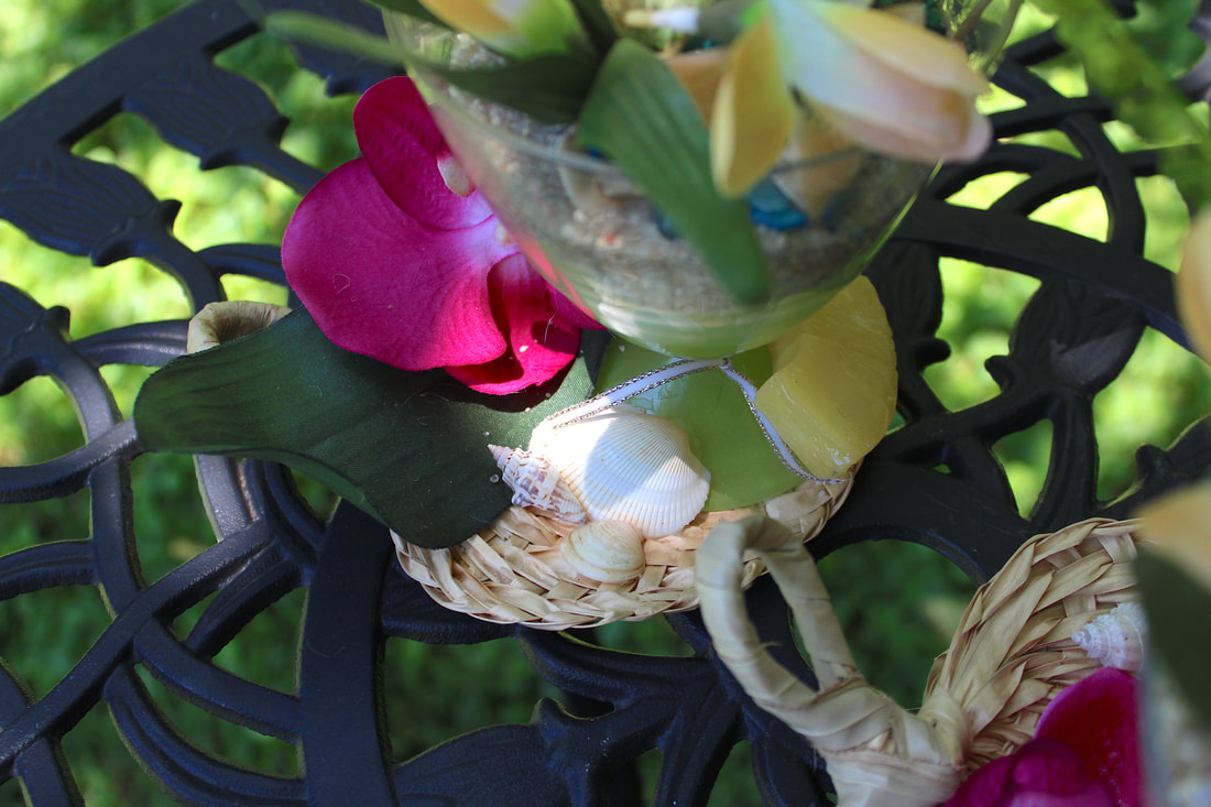 Repurposed dessert glass on a woven mat with tropical decor.