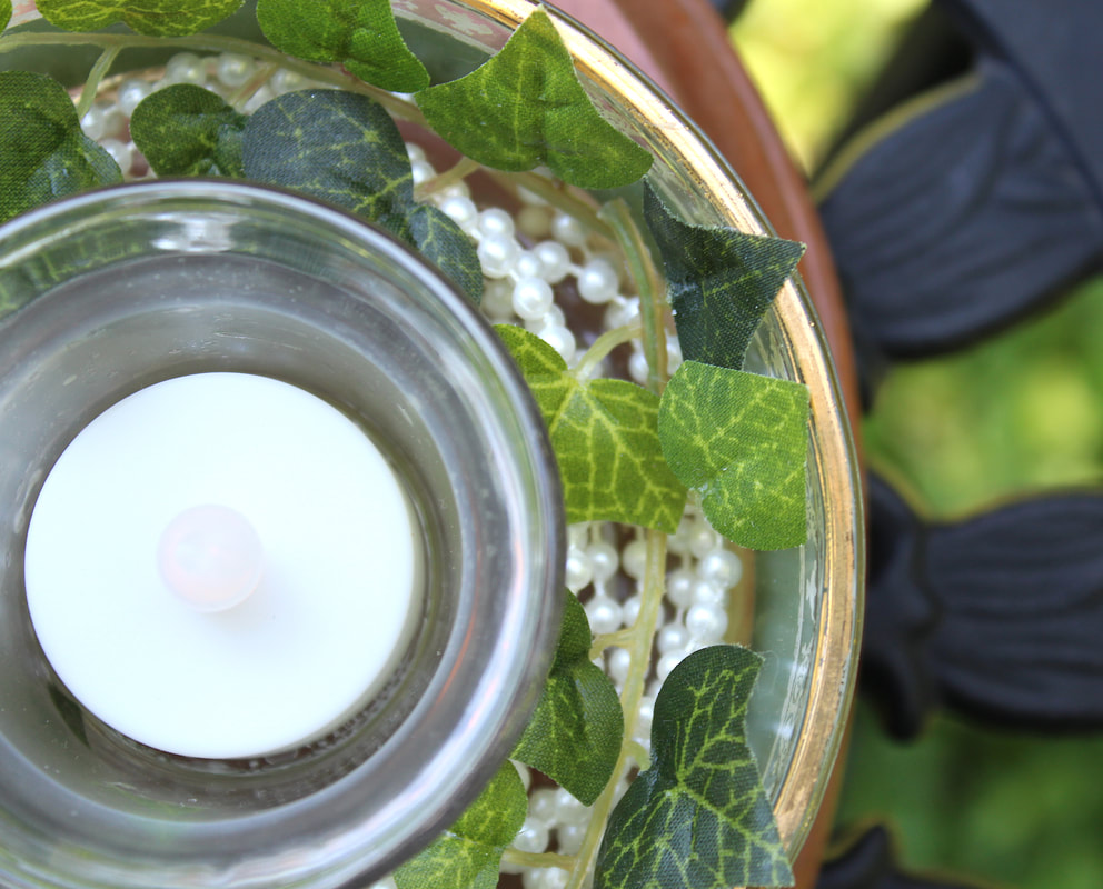 Closeup of faux vines in epurposed glassware.