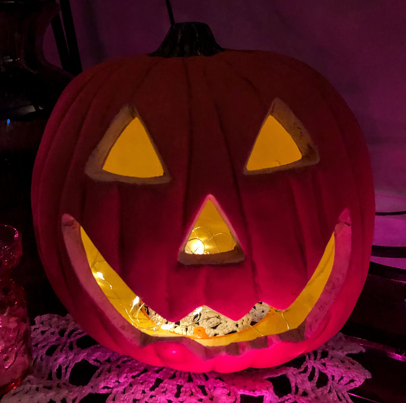 Plastic jack-o-lantern lit with lights.